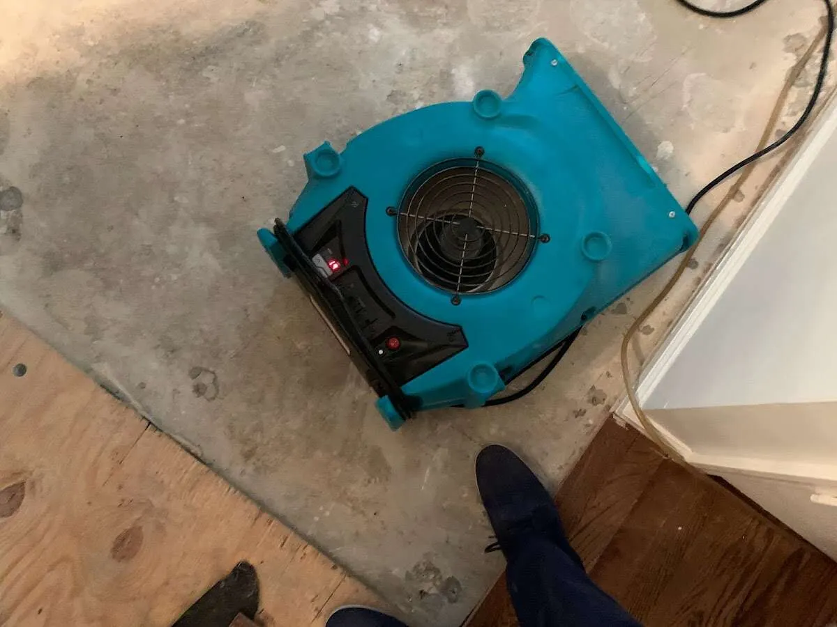Air mover drying subfloor during Commercial Water Damage Restoration in Hutchinson